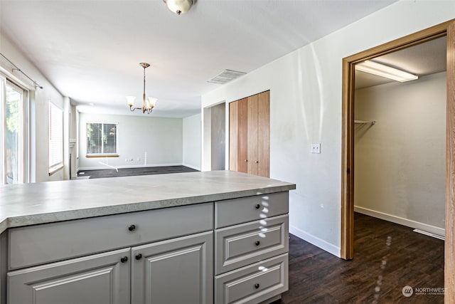 kitchen featuring gray cabinets, dark hardwood / wood-style flooring, decorative light fixtures, and an inviting chandelier