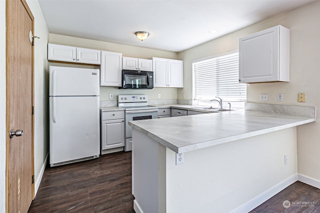 kitchen featuring electric stove, kitchen peninsula, white fridge, and white cabinets