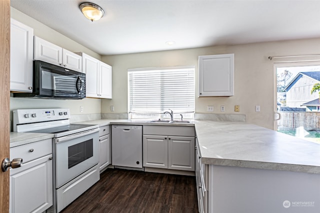 kitchen featuring white appliances, white cabinetry, sink, and dark hardwood / wood-style flooring