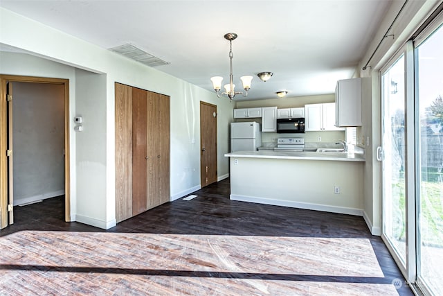 kitchen with dark wood-type flooring, white appliances, a healthy amount of sunlight, and sink