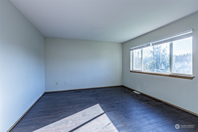 unfurnished room with dark hardwood / wood-style flooring