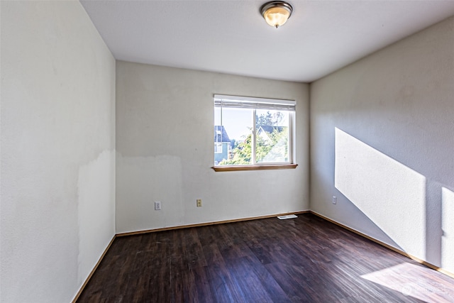 unfurnished room with dark hardwood / wood-style flooring