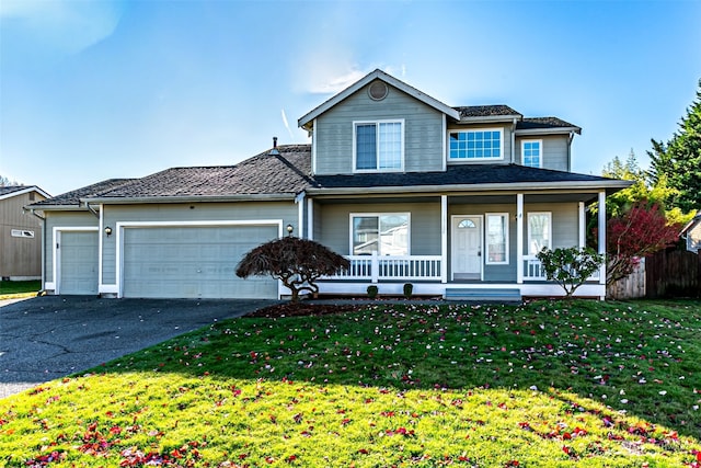 view of front of home featuring a front lawn, a garage, and covered porch