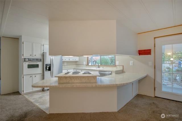 kitchen with a wealth of natural light, white cabinetry, kitchen peninsula, and appliances with stainless steel finishes