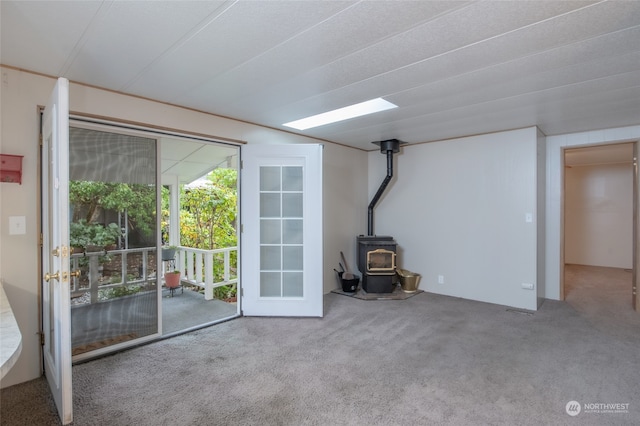 unfurnished living room with a wood stove and carpet