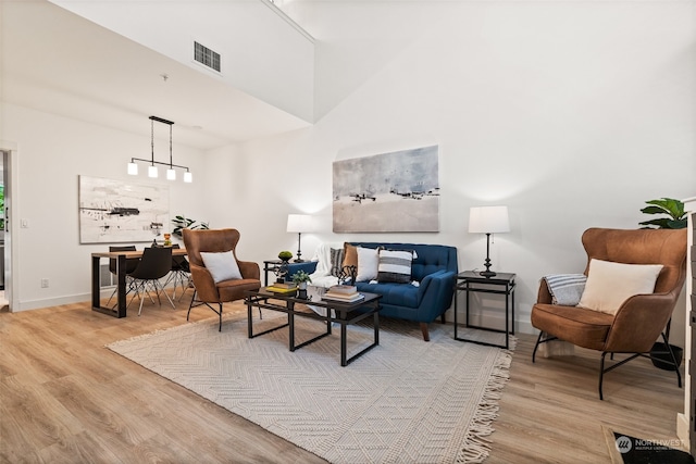 living area with light hardwood / wood-style floors and a high ceiling