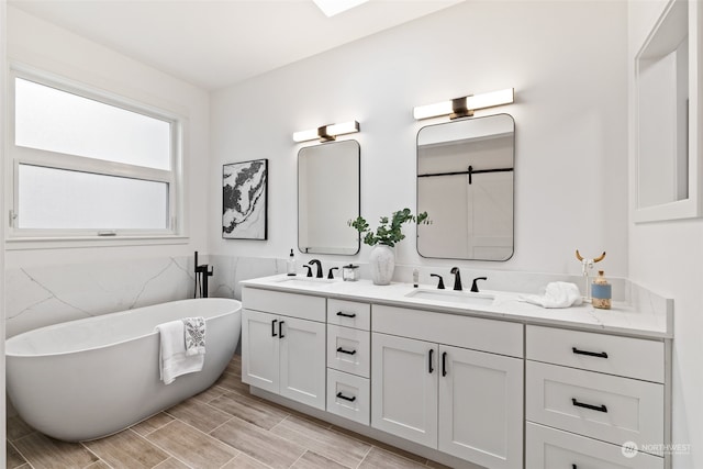 bathroom with a bathing tub, vanity, and tile walls