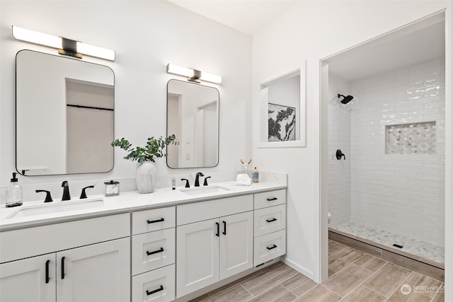 bathroom with a tile shower and vanity