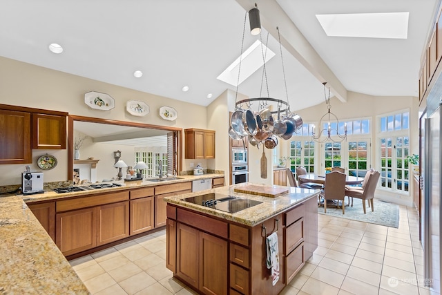 kitchen featuring light stone countertops, stainless steel appliances, light tile patterned floors, decorative light fixtures, and a chandelier