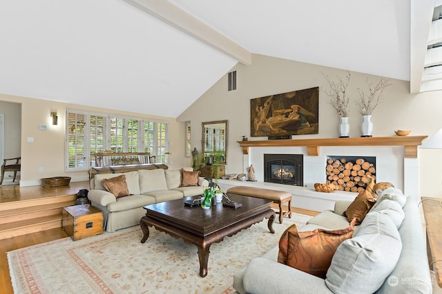 living room featuring beam ceiling, high vaulted ceiling, and wood-type flooring