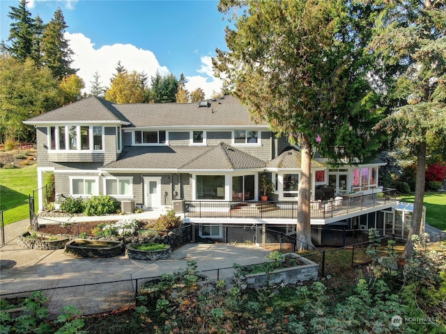 rear view of house featuring a patio, central AC, a lawn, and a wooden deck