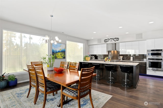 dining room with dark hardwood / wood-style floors, a healthy amount of sunlight, and an inviting chandelier