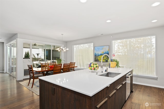 kitchen featuring a wealth of natural light, a center island with sink, sink, and dark hardwood / wood-style floors