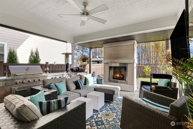 view of patio / terrace with an outdoor kitchen, grilling area, an outdoor living space with a fireplace, and ceiling fan