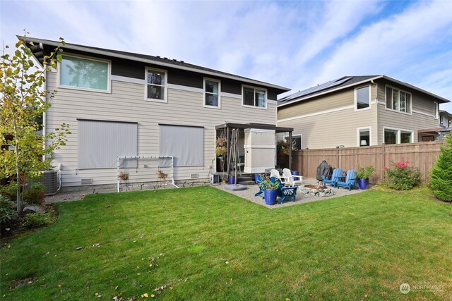 back of property featuring central AC, an outdoor fire pit, a patio, and a yard