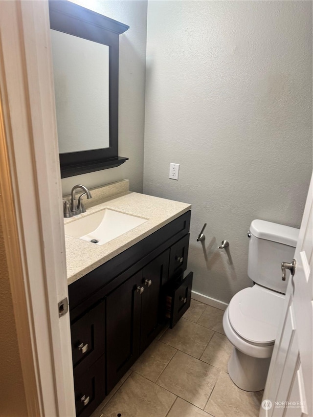 bathroom featuring tile patterned flooring, vanity, and toilet