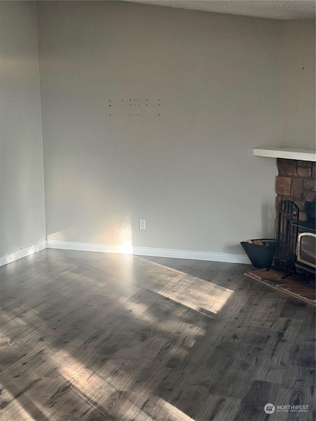 unfurnished living room with dark hardwood / wood-style floors and a wood stove