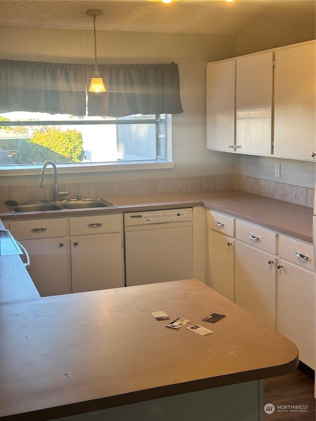 kitchen with sink, white cabinets, white dishwasher, and decorative light fixtures