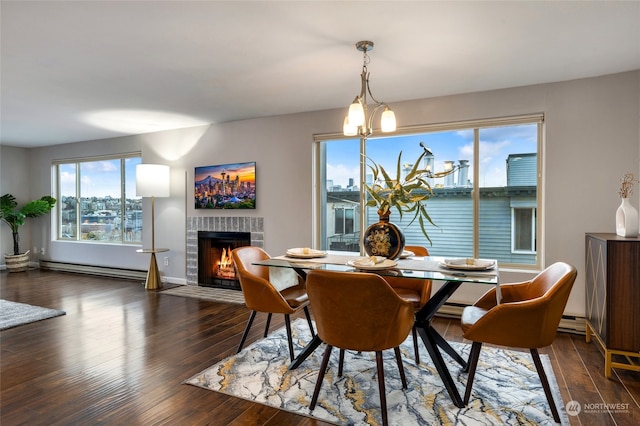 dining room with a chandelier, dark wood-type flooring, and a baseboard heating unit