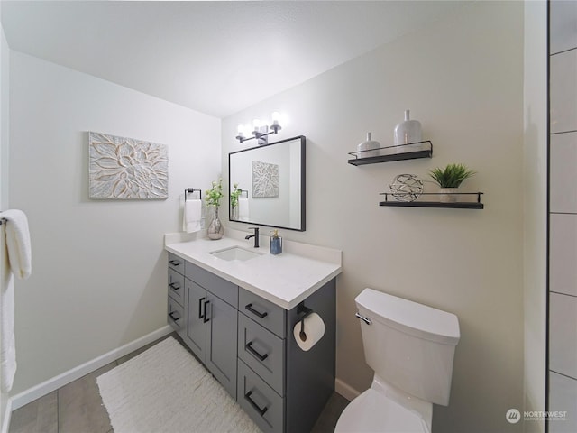 bathroom with vanity, an inviting chandelier, and toilet