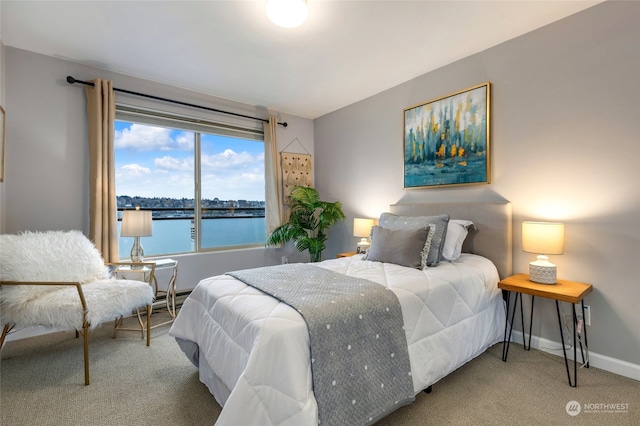 bedroom with carpet flooring and a water view