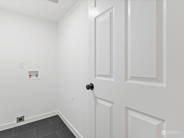 clothes washing area featuring hookup for an electric dryer, hookup for a washing machine, and dark tile patterned floors