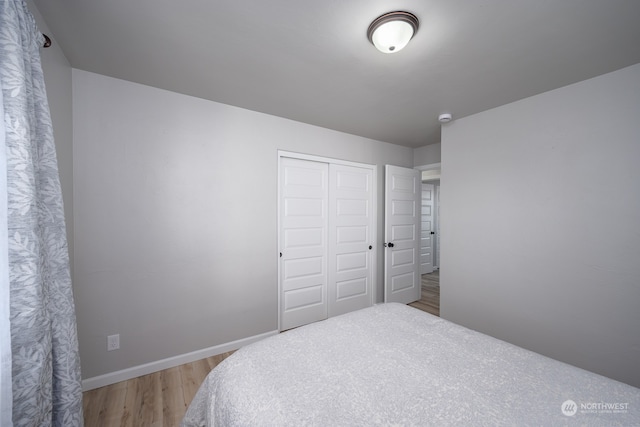 bedroom with light hardwood / wood-style floors and a closet