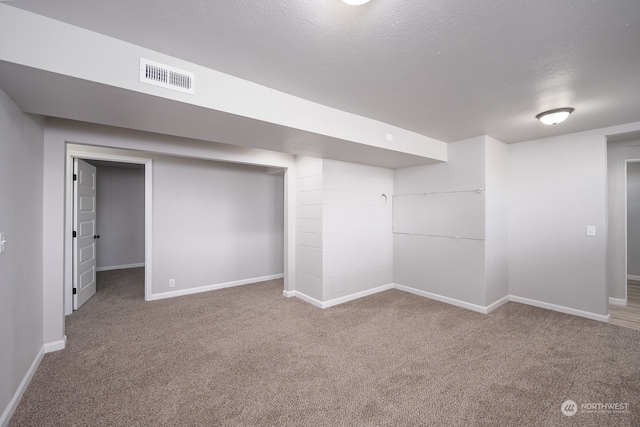 basement with a textured ceiling and carpet flooring