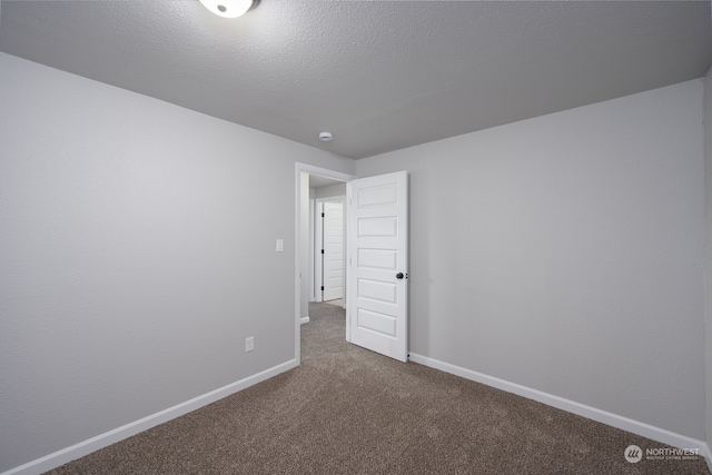 empty room featuring carpet floors and a textured ceiling