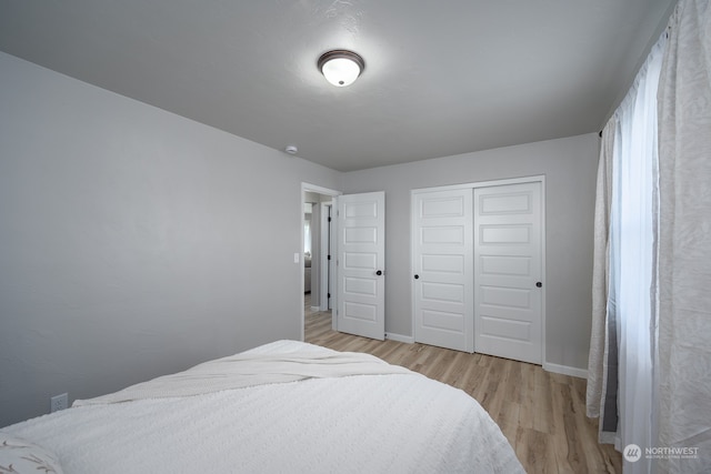 bedroom with a closet and light hardwood / wood-style floors