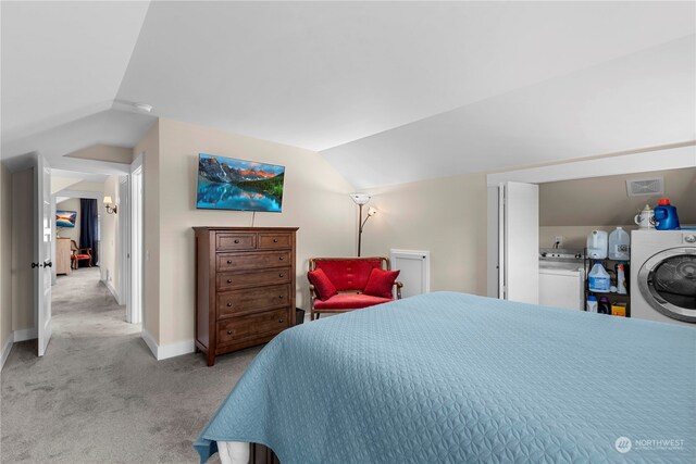 carpeted bedroom with separate washer and dryer and vaulted ceiling