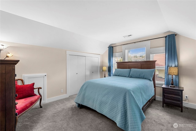 bedroom with a closet, lofted ceiling, and carpet flooring