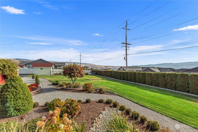 view of yard with a mountain view and a garage