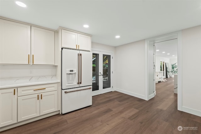 kitchen with light stone counters, high end white refrigerator, french doors, dark wood-type flooring, and white cabinetry