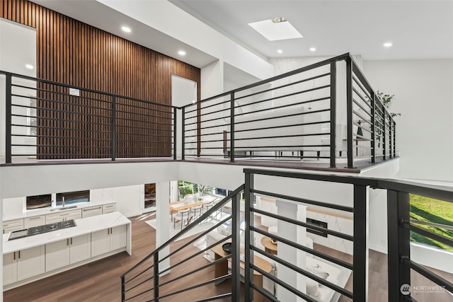 stairs with a skylight, recessed lighting, and wood finished floors