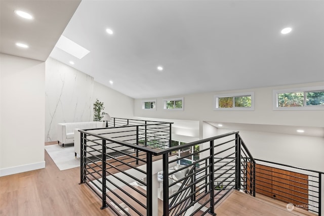 interior space with a healthy amount of sunlight, light wood-style floors, recessed lighting, and an upstairs landing