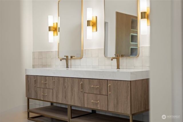 full bathroom featuring a sink, backsplash, and double vanity