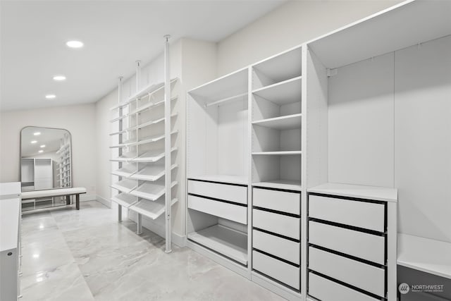 walk in closet featuring marble finish floor