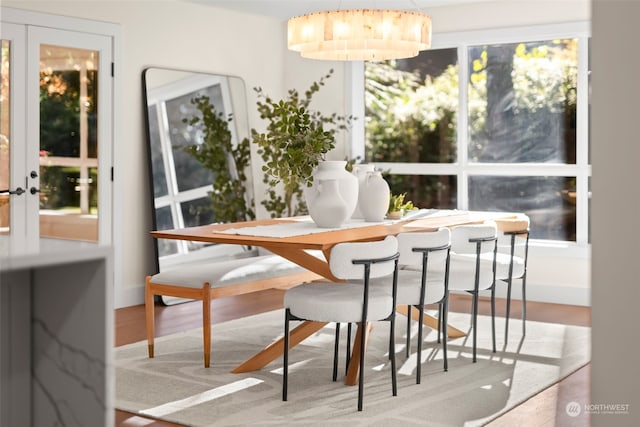 dining space with french doors and wood finished floors