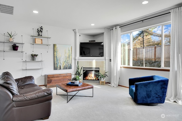 carpeted living room with a tiled fireplace