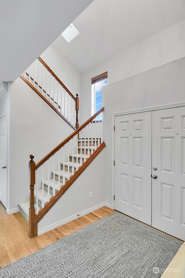 entryway featuring a skylight and wood-type flooring