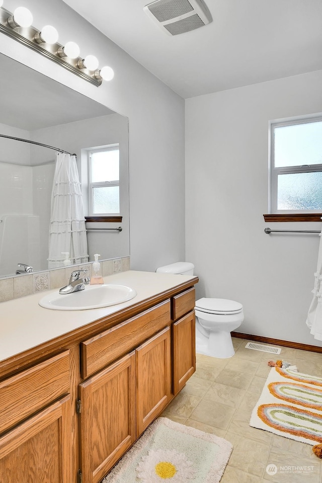 bathroom with a shower with shower curtain, vanity, and toilet