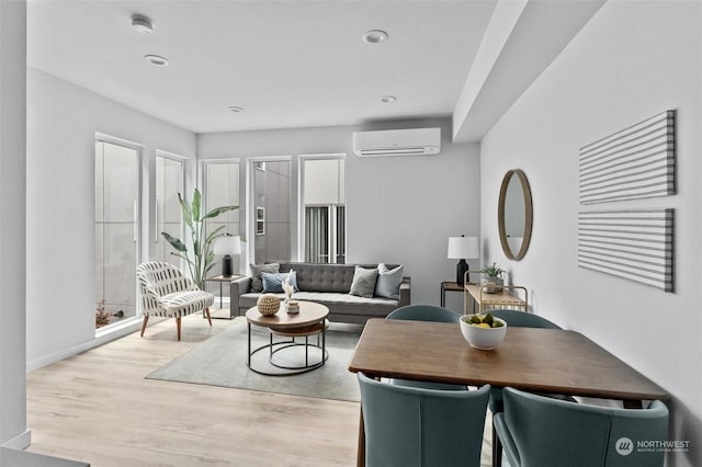 living room featuring light hardwood / wood-style flooring and a wall mounted air conditioner