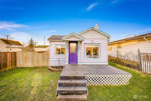 back of property with a wooden deck and a yard