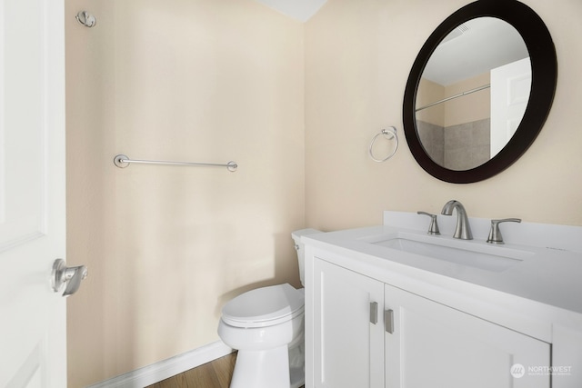 bathroom featuring wood-type flooring, vanity, and toilet