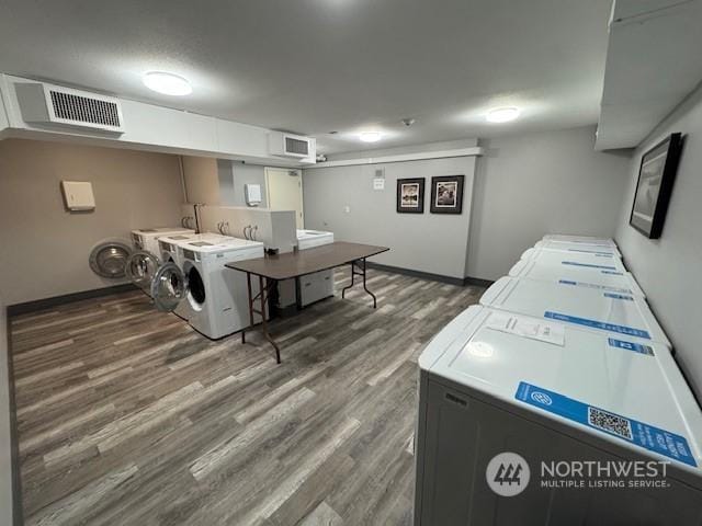 clothes washing area with independent washer and dryer and dark hardwood / wood-style flooring