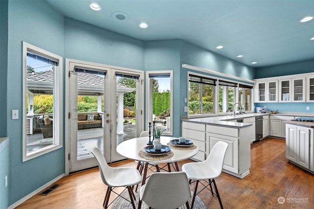 kitchen with white cabinetry, a wealth of natural light, sink, and hardwood / wood-style flooring