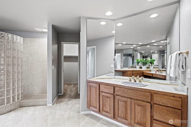 bathroom with vanity and a tile shower