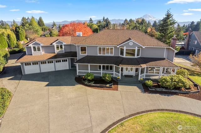 view of front of property with a garage, a mountain view, and covered porch