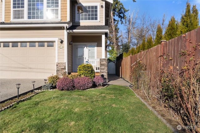 property entrance with a garage and a yard